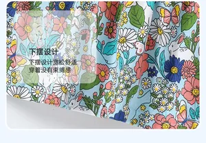 Détail de l'ourlet de robe fille bleu clair avec motif de lapin blanc et de marguerites