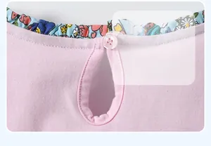 Détail du col volanté à fleurs et bouton au dos d'une robe rose pour petite fille