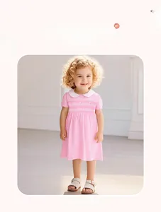 Dettaglio dell'abito estivo rosa in cotone con colletto Peter Pan e ricamo a nido d'ape
