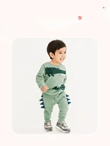 Detail of sage green toddler fleece set featuring crocodile print and dinosaur 3D spikes