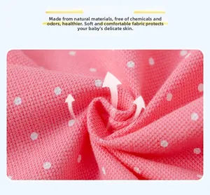 Detailed macro view of soft pink polka dot cotton knit fabric for baby polo dress