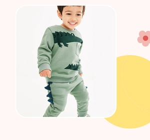 Detail of toddler boy set showing 3D crocodile spikes on green sweatpants and sweatshirt