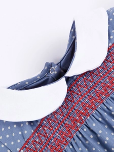 Girl's blue polka dot cotton dress with white Peter Pan collar and red smocked chest