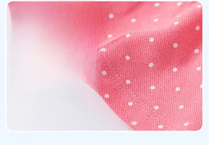 Detailed macro view of pink polka dot knit dress hemline showing pique mesh fabric texture