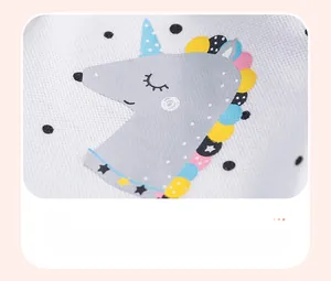 Detail showing a cute gray unicorn print on white knitted cotton girls' polo dress