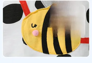 Dettaglio del ricamo a ape con pompon rosa su t-shirt per neonati in cotone a pois