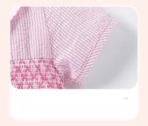 Gros plan d'une manche rayée rose et blanc avec smocks délicats et texture froncée