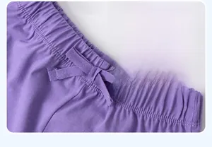 Detail of dark purple cotton pants with elastic waistband and decorative drawstring