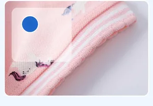 Detail of pink knitted girl's dress with unicorn print and striped ribbed cuff