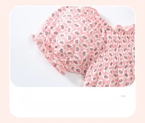 Détail d'une manche bouffante fleurie avec smocks et volants sur t-shirt fille en coton