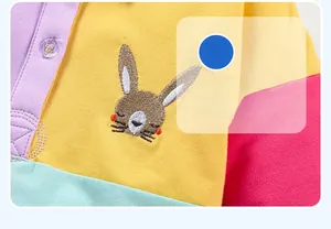 Detail of colorful patchwork cotton knit top with cute bunny embroidery and buttons