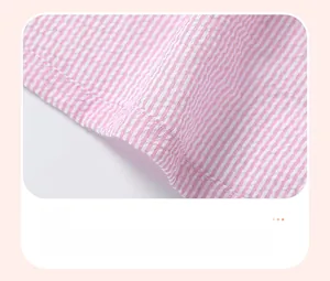 Gros plan détaillé de l'ourlet de robe en seersucker rayé rose et blanc avec coutures