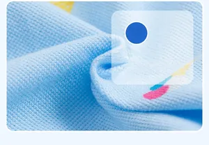 Macro shot of light blue piqué fabric showing honeycomb texture and colorful prints