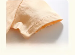 Détail des doubles coutures sur le revers de manche d'un T-shirt en coton enfant