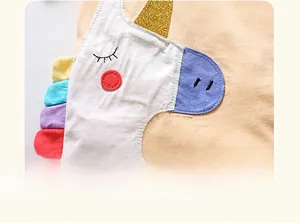Détail d'un t-shirt enfant en coton avec licorne brodée et corne à paillettes dorées