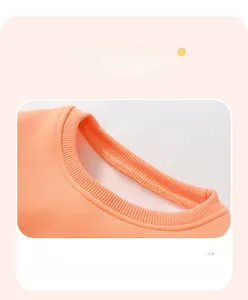 Detail of ribbed crew neck design with flatlock stitching on girls orange sweatshirt