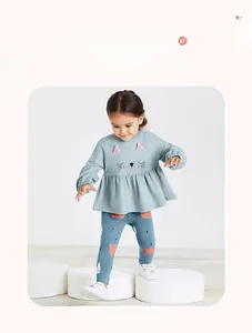 Detail of girl's blue cat sweatshirt with frilled hem and bear pattern leggings