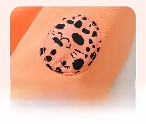 Detail of vibrant orange sweatshirt featuring a leopard print applique and tidy stitching