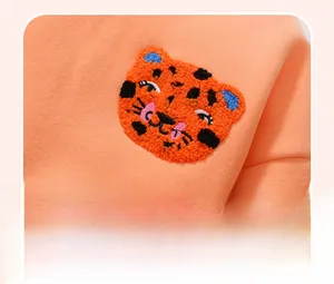 Detail of cute tiger towel embroidery on orange fleece sweatshirt for little girls