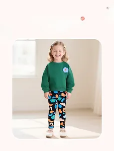 Detail showing girls long sleeve green sweatshirt with plush flower and floral pants