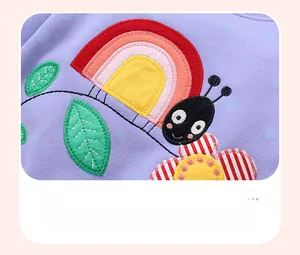 Vue détaillée de la broderie appliquée d'escargot et de fleur sur un sweat violet à pois