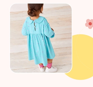 Dettaglio vestito blu in cotone per bambina con stampa farfalle e bottone in legno