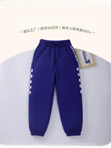 Detail of dark blue children joggers with checkered side stripes and drawstring waist