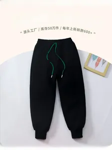 Close-up of thick fleece kids joggers with green drawstring and embossed side letters