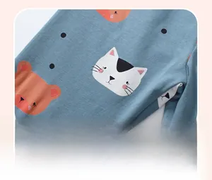 Close-up of light blue cotton fabric with cartoon cat, bear prints and discharge printing