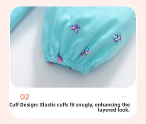 Dettaglio dei polsini elastici e stampa farfalla sul vestito in cotone blu chiaro