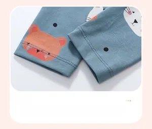 Detail of blue cotton baby pants cuffs featuring cute orange bear and white cat patterns