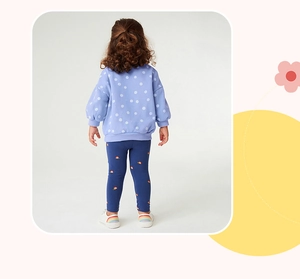 Vue arrière d'une fille en sweat violet à pois et ensemble legging arc-en-ciel