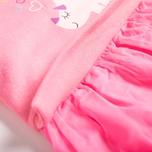 Dettaglio del corpetto in cotone rosa con stampa cartoon e gonna in tulle a più strati