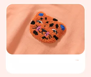 Detailed macro view of the cute tiger embroidery patch on orange cotton sweatshirt