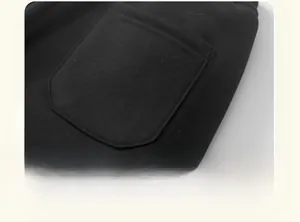 Detailed macro view of reinforced double-needle stitching on thick black cotton trousers