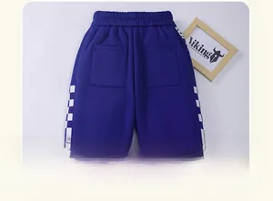 Detail of blue winter fleece pants for boys with checkerboard side stripes and back pockets