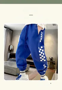 Close-up of bright blue kids jogger pants with checkerboard side stripe and ribbed cuffs