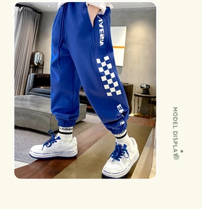 Detail of dark blue boys joggers with checkerboard side patterns and elastic drawstring waist