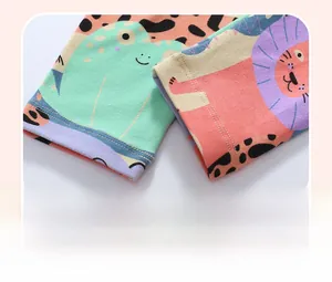 Close-up of children's cotton pants hem featuring vibrant cartoon animal prints and stitching
