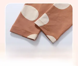 Detailed view of elastic ribbed cuffs on girls rust orange pants with white polka dots