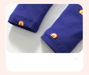 Gros plan détaillé des poignets avec motif escargot arc-en-ciel sur tissu en coton bleu