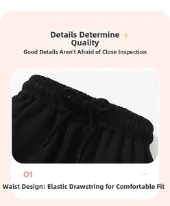 Detail of boys' black cotton joggers featuring an elastic waistband with drawstring
