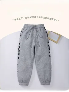 Detail of grey fleece-lined kids joggers with checkered side stripes and drawstring waist