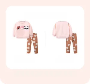 Flat lay of pink sweatshirt with animal embroidery and dark polka dot cotton trousers