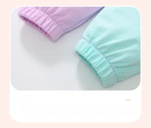Detailed close-up of elastic ribbed cuffs on purple and mint green cotton girl joggers
