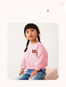 Detail view of pink girls sweatshirt featuring a soft bear embroidery patch and ribbed cuffs