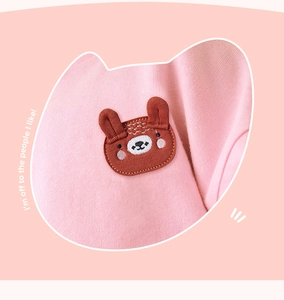 Detail of pink fleece sweatshirt featuring a cute brown bear embroidery and text