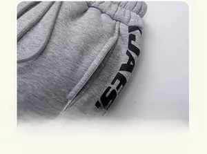 Detail of gray kids joggers with elastic waistband, drawstring and side letter print