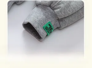 Macro detail of ribbed cuff on grey children's trousers with green decorative label