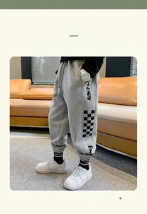 Detail of grey fleece-lined jogger pants for boys featuring checkerboard print and letters
